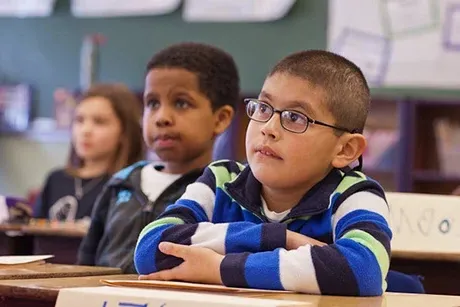 elementary students at their desks listening